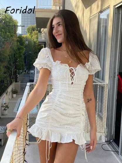 Abito estivo bianco ricamato con lacci da donna scava fuori abito corto da spiaggia manica a sbuffo volant increspato aderente mini abito abiti